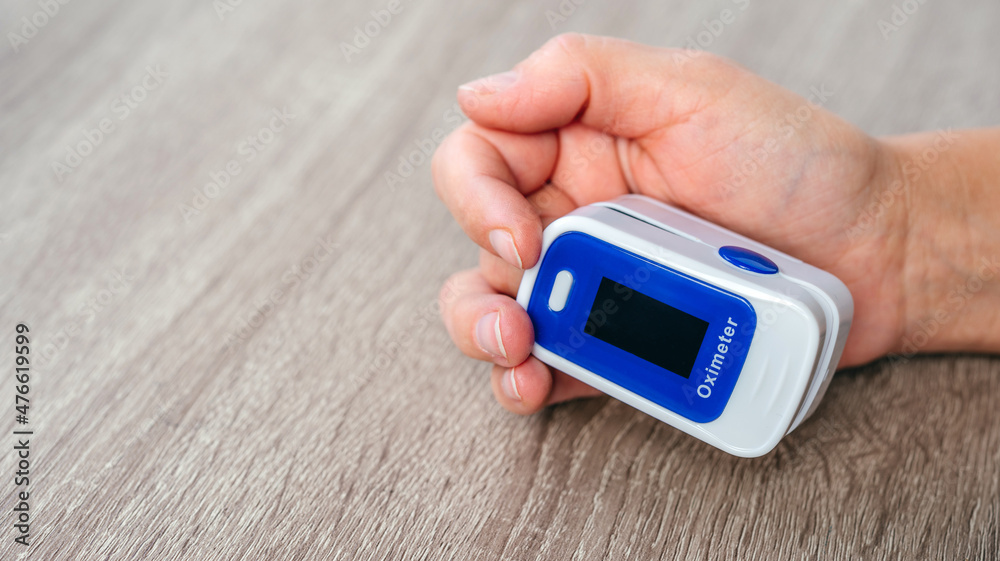 Home pulse oximeter, patient measuring the blood oxygen with oximeter Home pulse oximeter, patient measuring the blood oxygen with oximeter