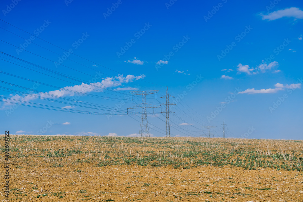 Electric power transmission lines at sky background, autumn field