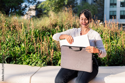 businesswoman taking a laptop out of her briefcase photo