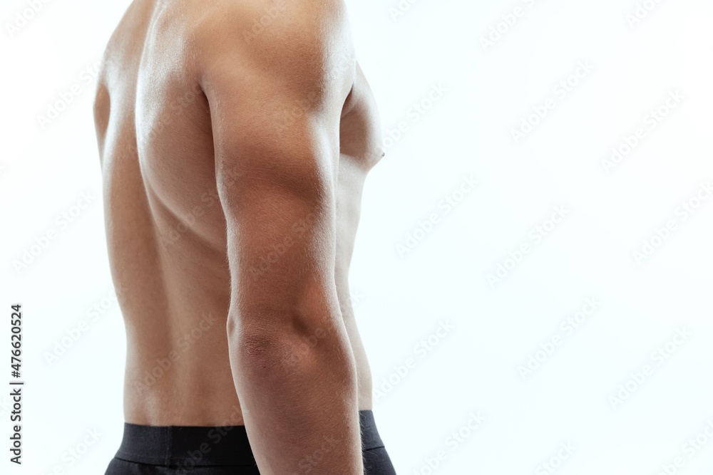 Naklejka premium Cropped portrait of young muscled shirtless sportive man posing isolated on white background.