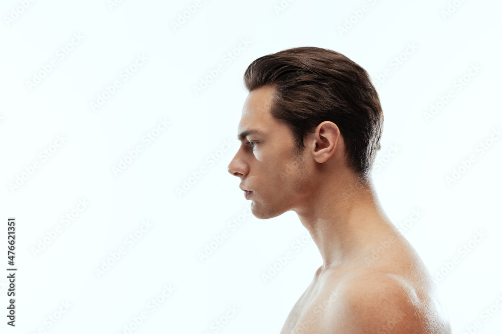 Profile view of young handsome man isolated on white studio background. Concept of men's health and beauty Profile view of young handsome man isolated on white studio background. Concept of men's health and beauty