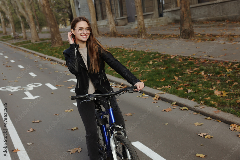 Fototapeta premium Happy beautiful woman with bicycle on lane in city