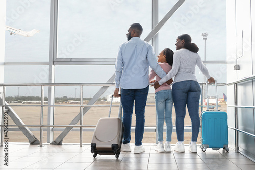 Black family traveling, waiting for the aircraft arrival
