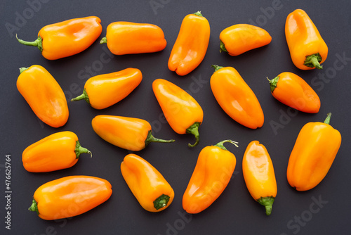 Top view of orange mini sweet peppers on black background. Healthy food.