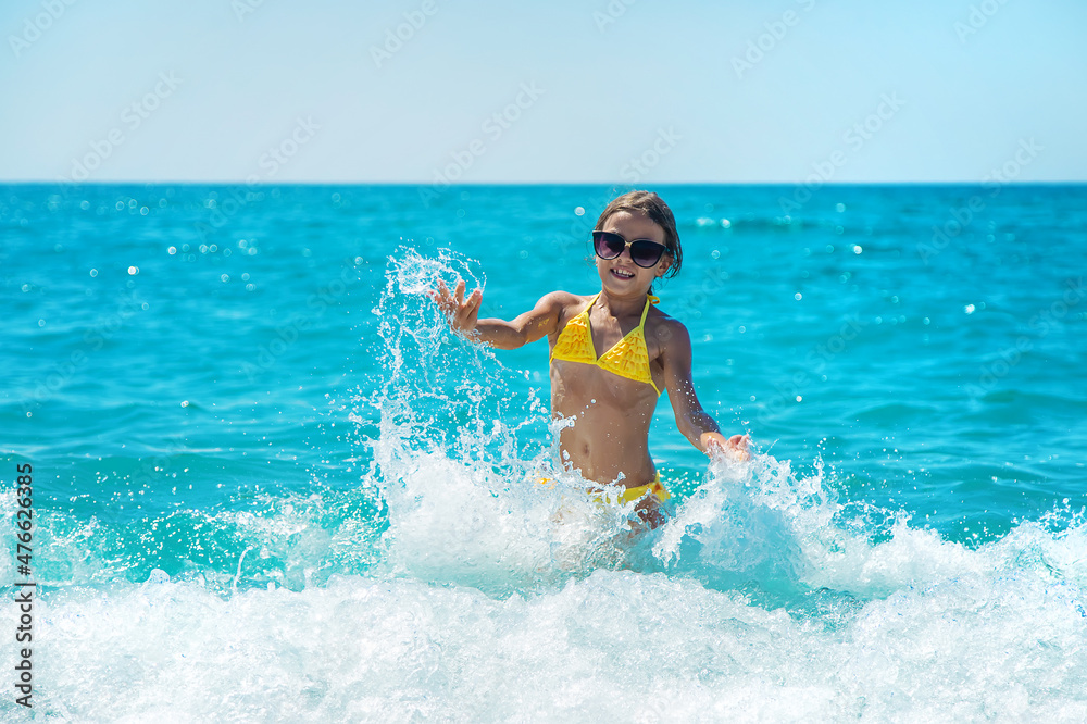 A child splashes water on the sea. Selective focus.
