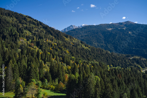 Autumn in the Italian Alps. Alps aerial view. Mountains in Europe top view. Forest plantations in the European Alps. Autumn in the mountains of Italy.