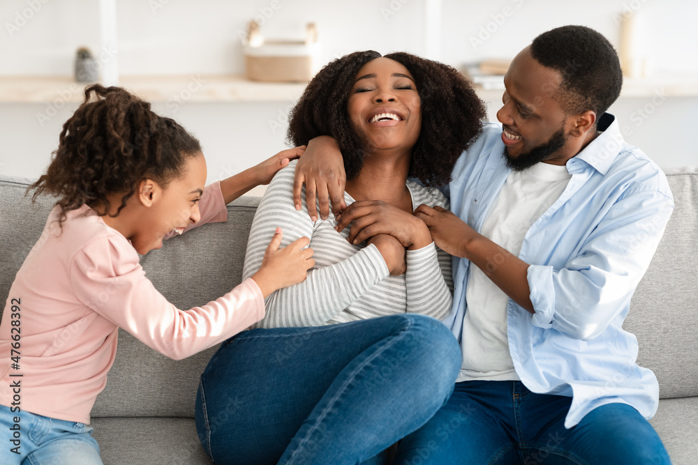 Portrait of a happy black family tickling mom at home Portrait of a happy black family tickling mom at home