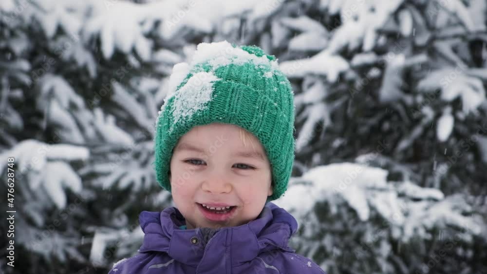 Portrait of happy excited little child boy smiling looking at camera standing outdoor under snow-covered trees. Happy 5 years kid joy at winter. Positive and happiness concept. Portrait of happy excited little child boy smiling looking at camera standing outdoor under snow-covered trees. Happy 5 years kid joy at winter. Positive and happiness concept.