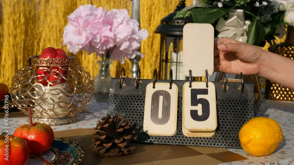 4K footage real time for 10 seconds countdown. hand turning page on flip vintage metal calendar digit number 9 countdown to digit number 0, on the table with party decoration. countdown for new year