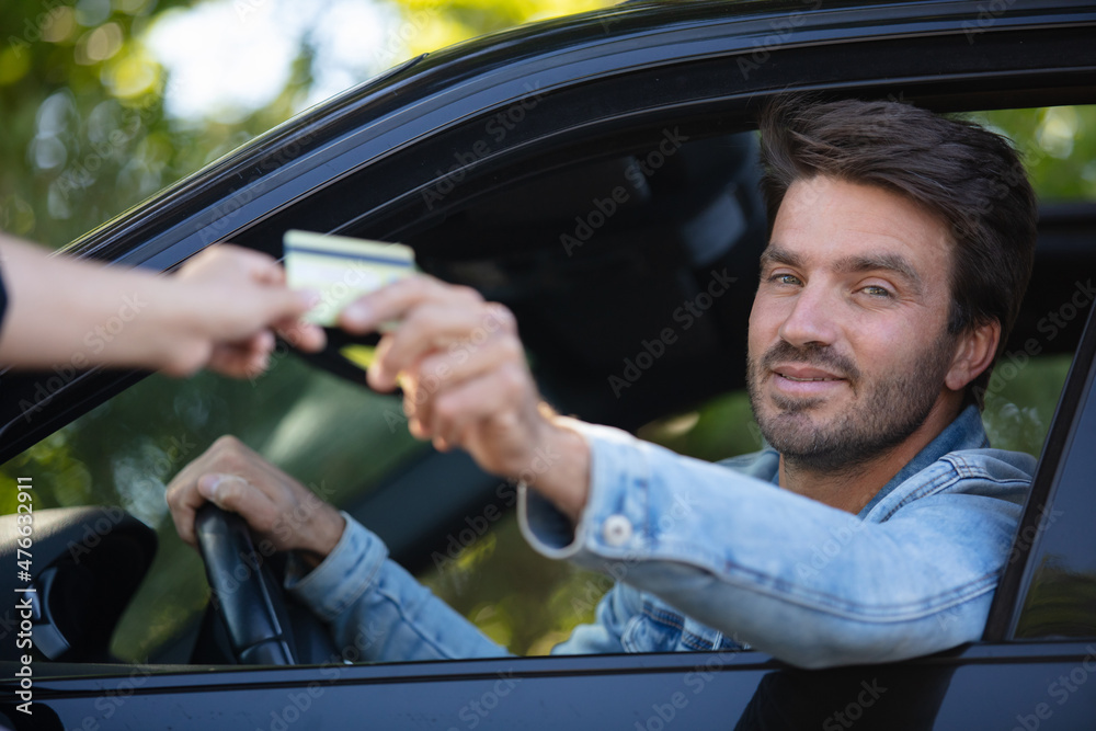 male motorist making car payment through window