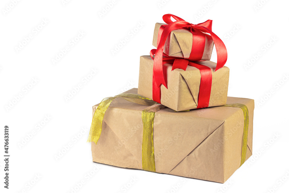 Obraz premium Gift box wrapped in Kraft paper with red and golden ribbon on white background. Holiday or Christmas gift boxes background.
