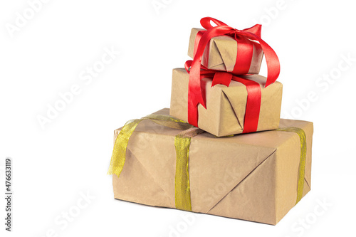 Gift box wrapped in Kraft paper with red and golden ribbon on white background. Holiday or Christmas gift boxes background.