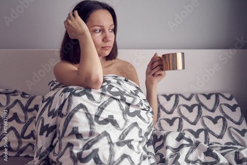 woman in bed with a mug