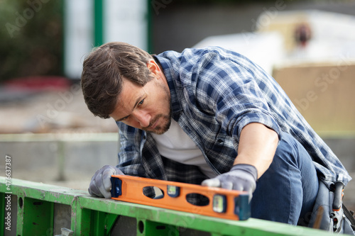 man using a spirit level to check a surface