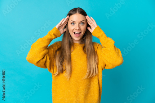 Young Lithuanian woman isolated on blue background with surprise expression