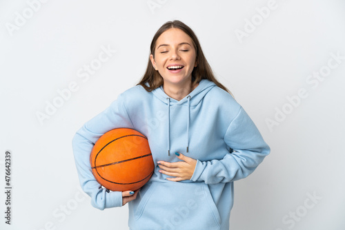 Young Lithuanian woman playing basketball isolated on white background smiling a lot