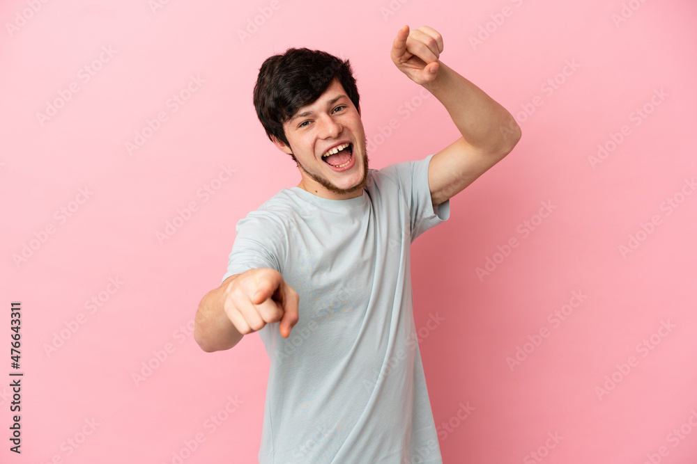Young Russian man isolated on pink background pointing front with happy expression Young Russian man isolated on pink background pointing front with happy expression