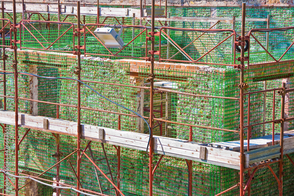 Italian construction site with carbon fiber weave for restoring, repairing and rebuilding of an old building with supporting structure in brick masonry