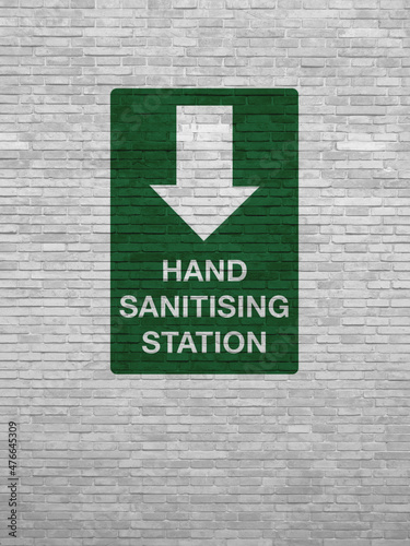 White brick wall with the inscription: HAND SANITISING STATION.