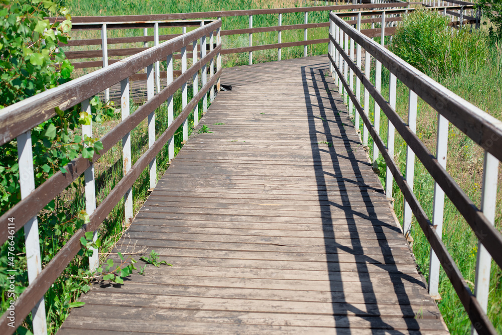 Wooden bridge with railings in summer
