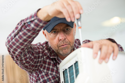 male technician fixing electric heater