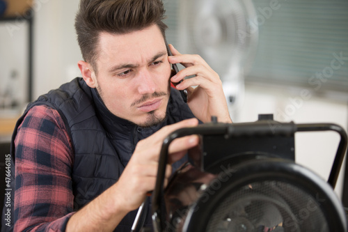 technician repairing appliance makes call on smartphone