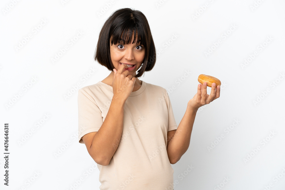 Young mixed race pregnant woman isolated on white background holding a donut Young mixed race pregnant woman isolated on white background holding a donut