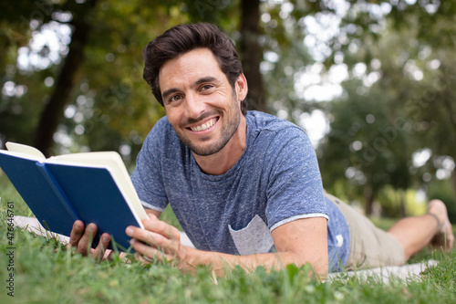 young man reading book outdoors