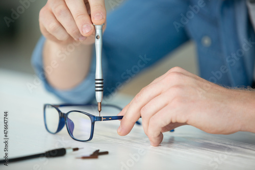 optician repairing and fixing eye glasses photo