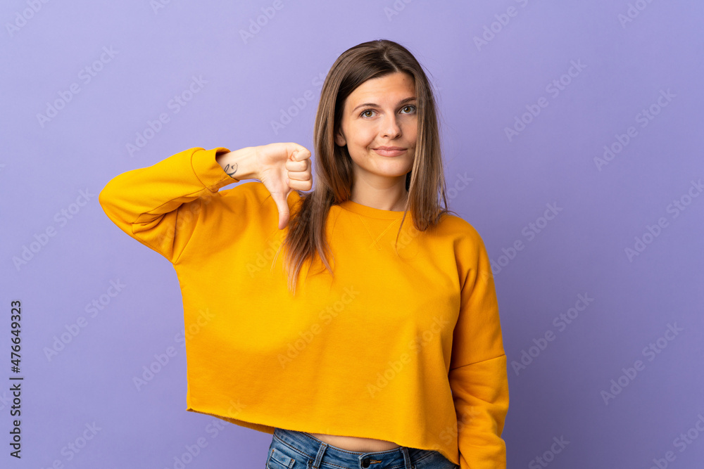 Young Slovak woman isolated on purple background showing thumb down with negative expression Young Slovak woman isolated on purple background showing thumb down with negative expression