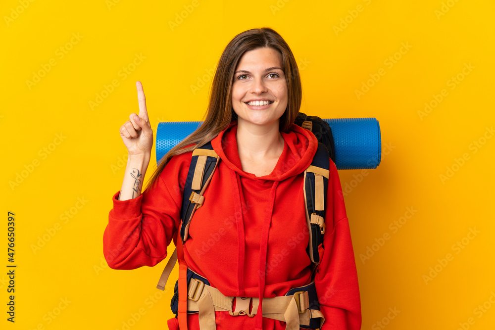Slovak mountaineer woman with a big backpack isolated on yellow background pointing up a great idea Slovak mountaineer woman with a big backpack isolated on yellow background pointing up a great idea