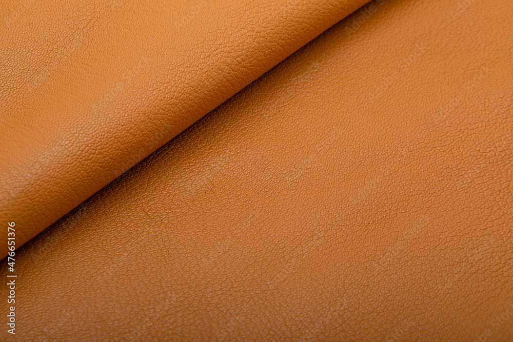 Fototapeta premium Sand brown colored folded natural leather on the wooden table
