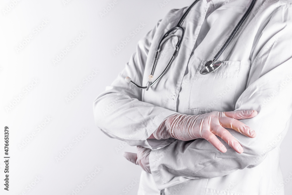 Female doctor with stethoscope and posing arms crossed, on light background close up image.
