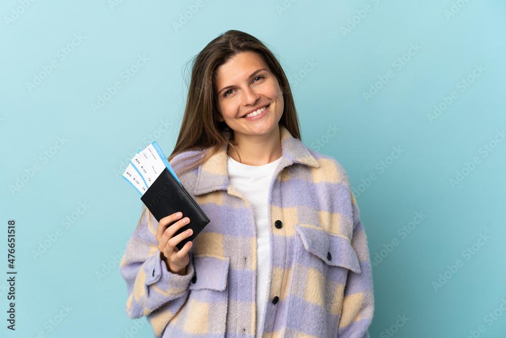 Young Slovak woman isolated on blue background happy in vacation with passport and plane tickets Young Slovak woman isolated on blue background happy in vacation with passport and plane tickets