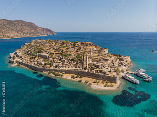 Drone shot from the island of Spinalonga with its fortress next to crete with ocean and coast