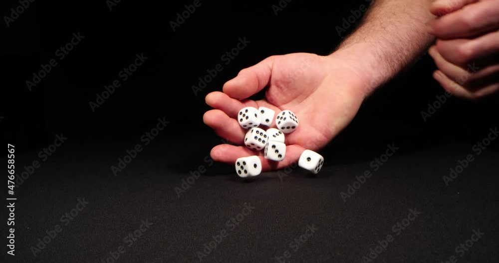 Rolling White dice on a black background. Hand dropping dice. Macro shot, side-view camera tracking. 4k
