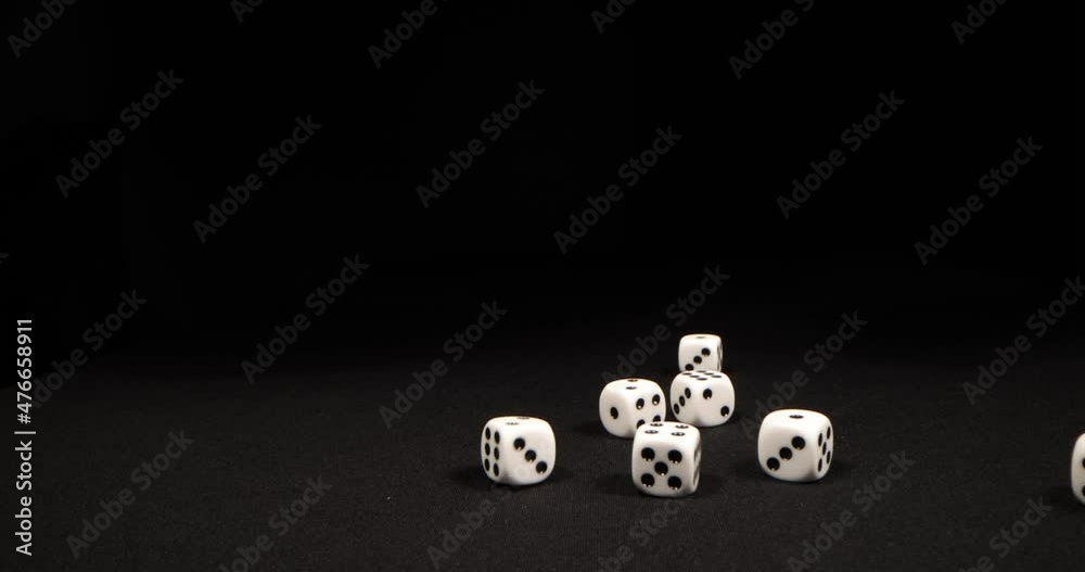 Rolling White dice on a black background. Hand dropping dice. Macro shot, side-view camera tracking. 4k Rolling White dice on a black background. Hand dropping dice. Macro shot, side-view camera tracking. 4k