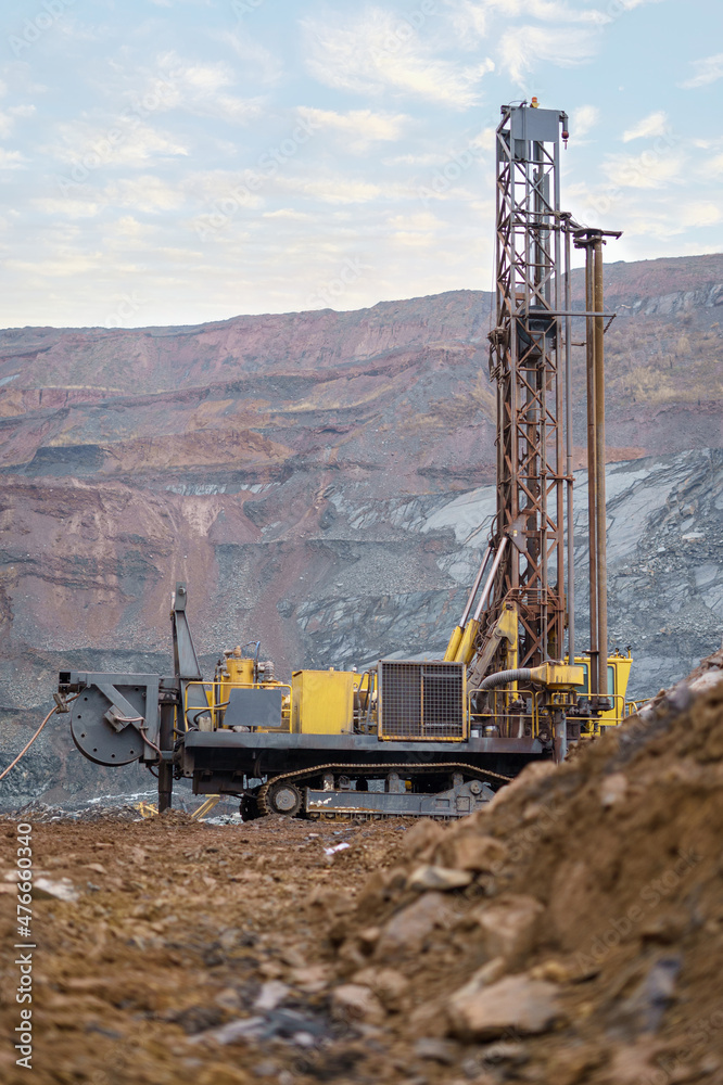 Large drill rig in an ore quarry. Preparation of boreholes for laying explosives in the quarry. Open-pit mining technologies. Large drill rig in an ore quarry. Preparation of boreholes for laying explosives in the quarry. Open-pit mining technologies.