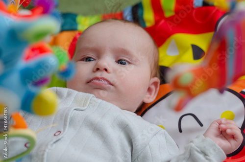 Baby looks at hanging rattles, close-up