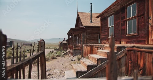 Creepy old abandoned wooden house with nesting birds flying all around in a western ghost town in the gold rush mining area of California photo
