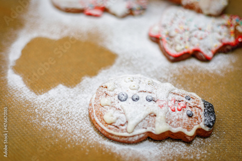 Christmas cookies sprinkled with icing sugar on a baking sheet. Christmas tree and snowman cookie shape.