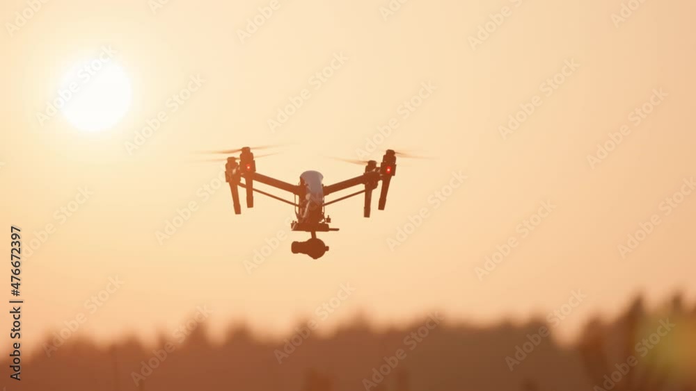 At sunset flying quadcopter drone scanning agricultural landscape harvest crops vehicle aircraft. Computer analyze. Innovation technology. Smart farming.