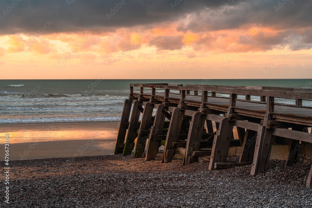 Wooden pier at the beach of Atlantic ocean in Normandy at sunset Wooden pier at the beach of Atlantic ocean in Normandy at sunset