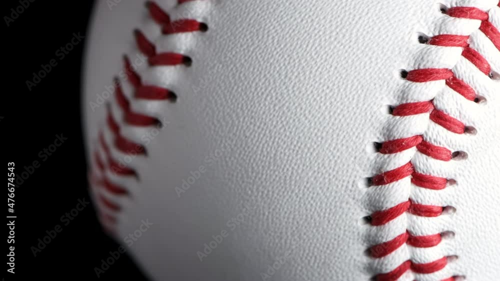 Close up of rotating baseball with black background.