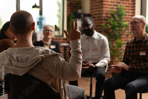 Man with addiction sharing health problems with group at aa meeting, talking to therapist. Alcoholic people having conversation about depression and rehabilitation at therapy session. photo