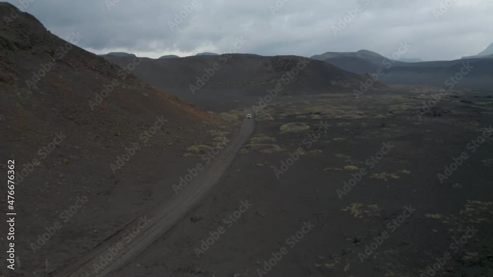High angle view car driving peacefully through desert remote dust road in icelandic highlands. Drone view 4x4 suv vehicle discovering wilderness iceland countryside. Adventure and exploration High angle view car driving peacefully through desert remote dust road in icelandic highlands. Drone view 4x4 suv vehicle discovering wilderness iceland countryside. Adventure and exploration