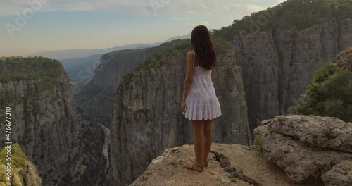 Tourist woman in white dress standing on the edge of the mountaing cliff against the backdrop of a gorge. Amazing Tazi Canyon ,Bilgelik Vadisi in Manavgat, Antalya, Turkey. Greyhound Canyon, Wisdom photo