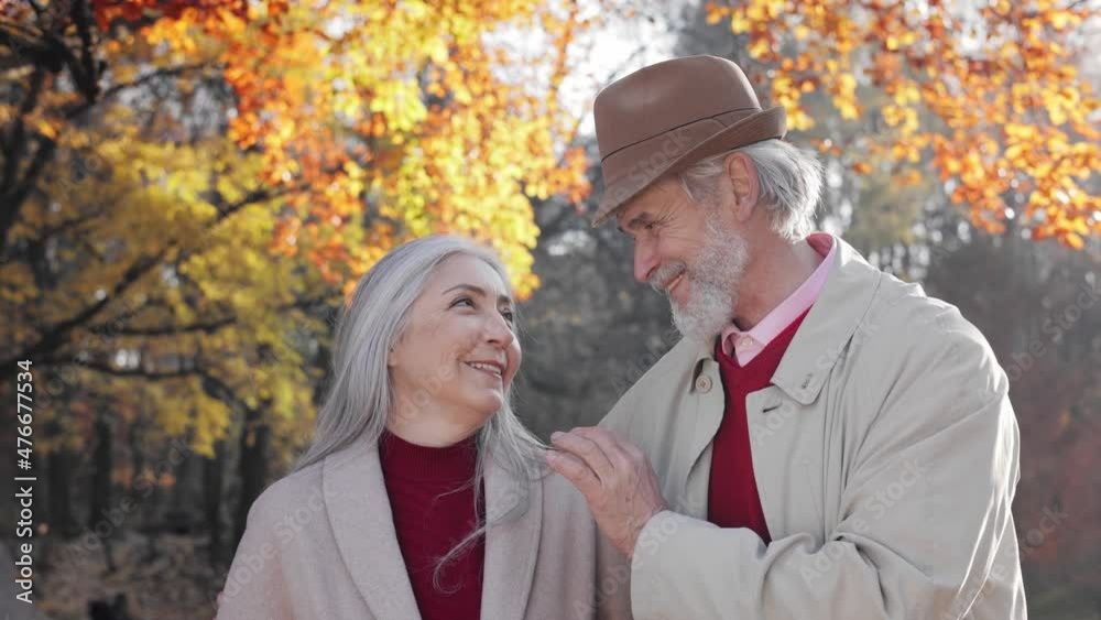 Portrait of happy old mature retired couple. Middle aged spouses enjoying time together in autumn park.talking and smiling to each other. Portrait of happy old mature retired couple. Middle aged spouses enjoying time together in autumn park.talking and smiling to each other.