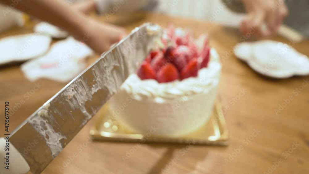子供の誕生日ケーキをカットする手元 子供の誕生日ケーキをカットする手元