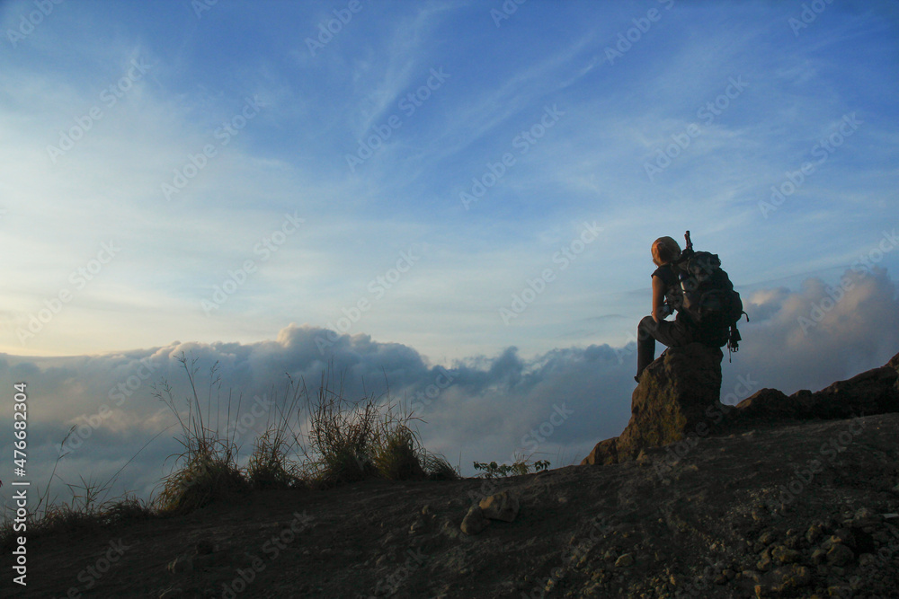 A woman standing at the top of mount Batur in Bali Indonesia. A woman standing at the top of mount Batur in Bali Indonesia.